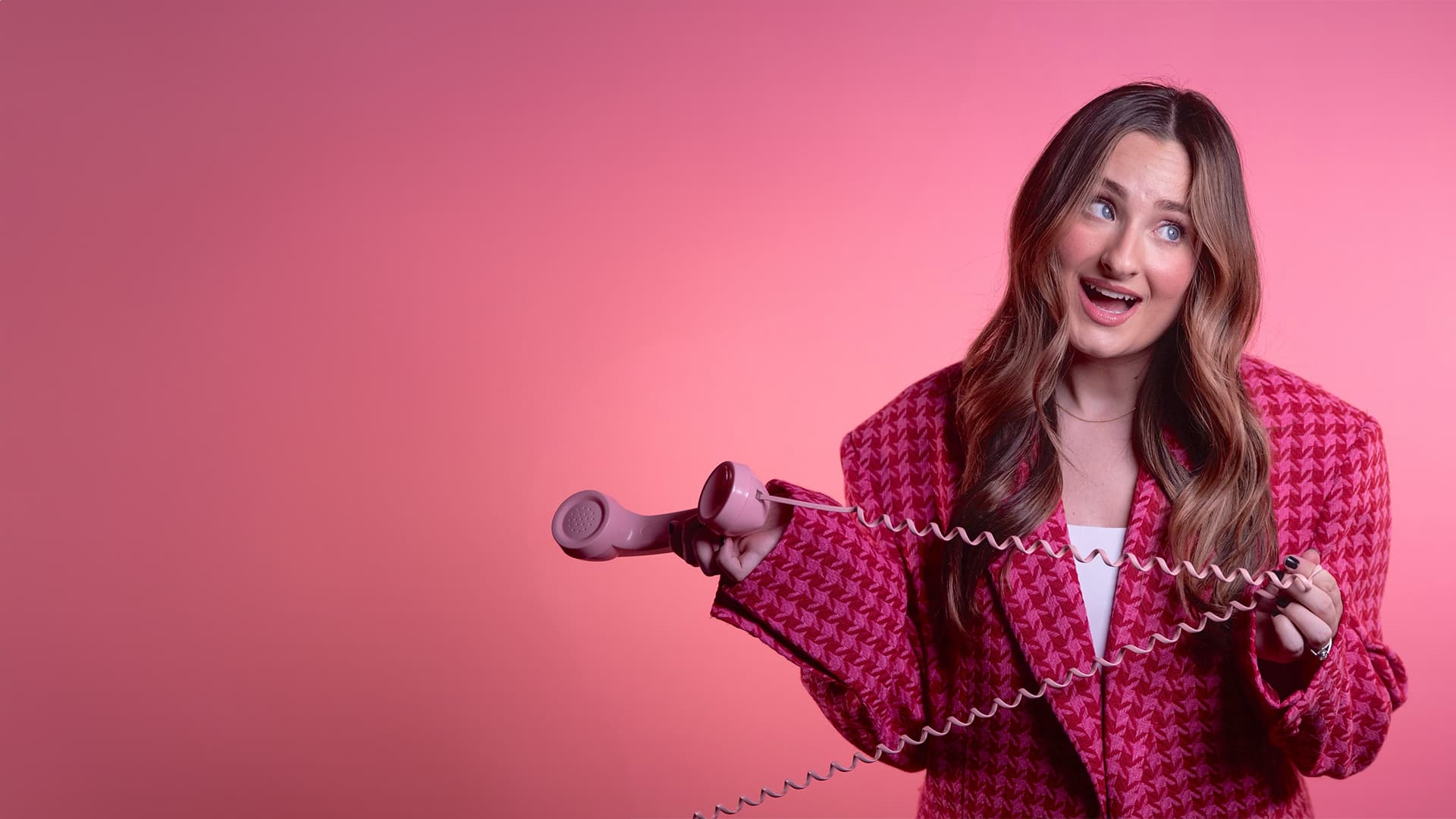 Hanna Ward holding a pink phone against a pink background